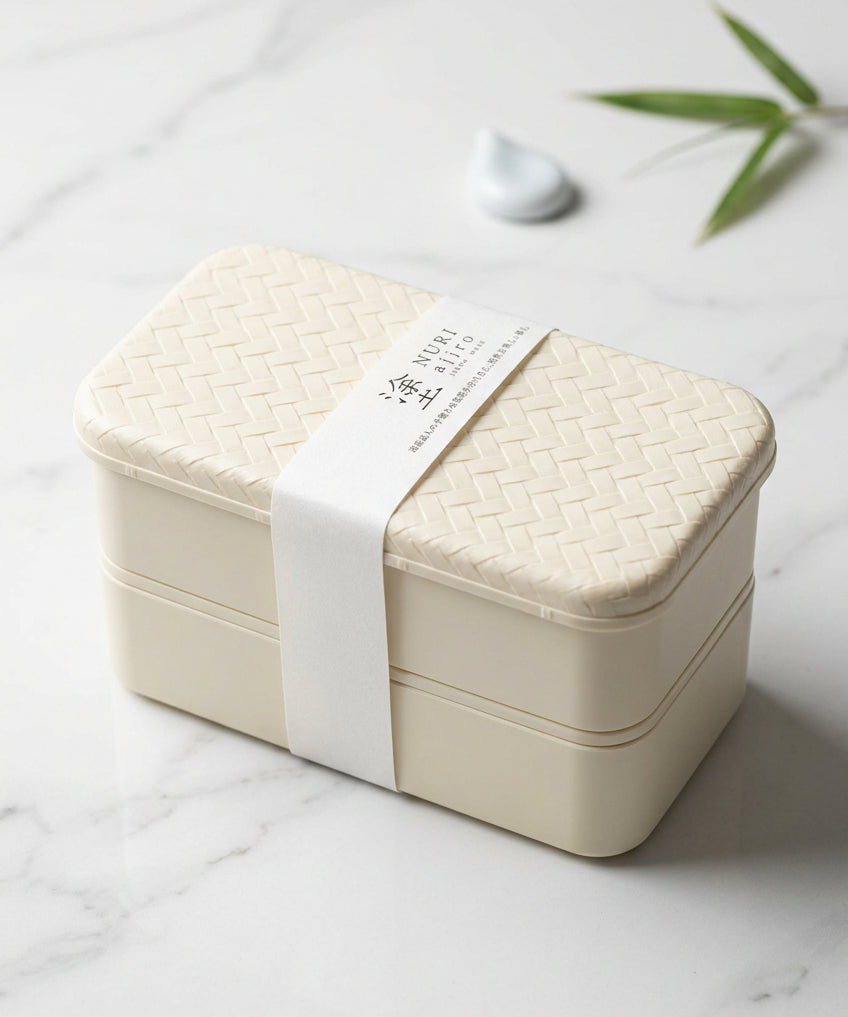 Boîte bento noire à deux niveaux avec couvercle à motif tressé.