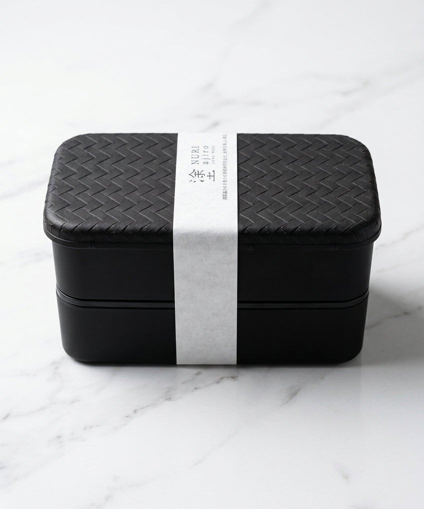 Boîte bento noire Nuri Ajiro à deux niveaux avec bande de présentation.