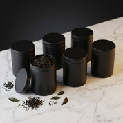 Six petites boîtes noires destinées au coffret de thés en vrac.