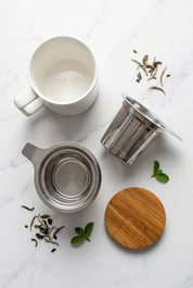 Tasse blanche, infuseur amovible en métal et couvercle effet bois.