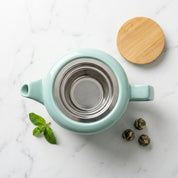 Vue de dessus de la théière bleu-vert, avec infuseur en métal et couvercle retiré.